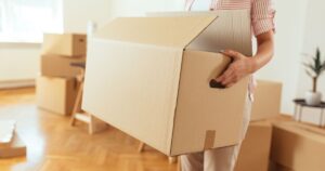 海外引っ越し準備で段ボールを持ち、荷物整理をしているイメージ写真